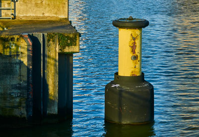 Close-up of yellow bottle on water