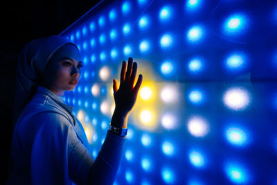 Portrait of woman holding illuminated lights