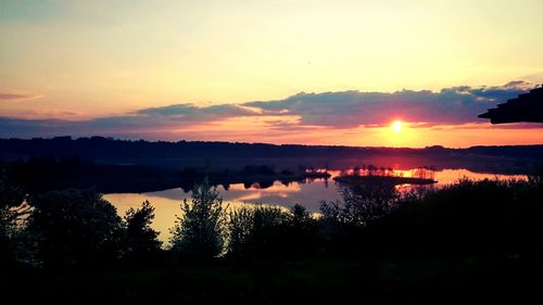 Scenic view of lake against orange sky