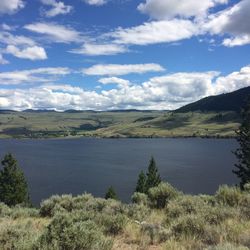 Scenic view of landscape and lake against cloudy sky