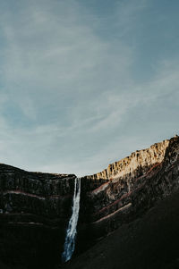 Scenic view of waterfall against sky