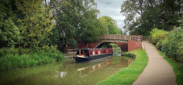 Bridge over canal against trees