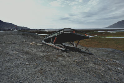 Abandoned car on land against sky