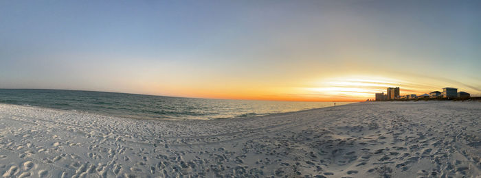 Scenic view of beach against clear sky during sunset