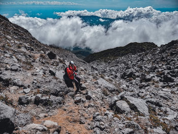 Panoramic view of people on rock against sky