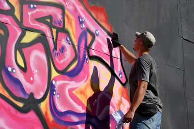 Rear view of man standing on wall