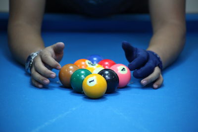 Close-up of person playing with balls on pool table