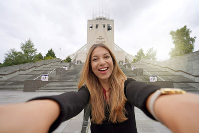 Beautiful young woman taking selfie photo in front of liverpool metropolitan cathedral in england,uk