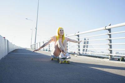 Full length of man skateboarding on road against sky