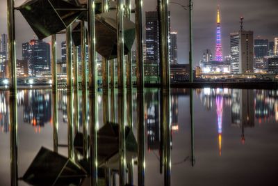 Illuminated cityscape against sky at night