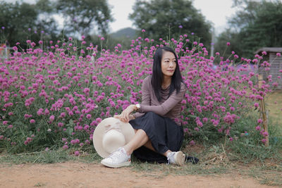 Portrait of young woman sitting on field