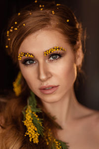 Portrait of a young woman in yellow mimosa flowers