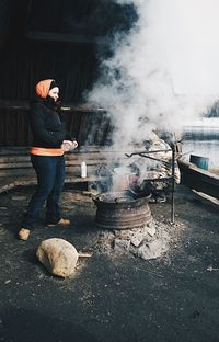 Side view of friends preparing barbecue by lake