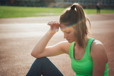 Female athlete sitting on running track