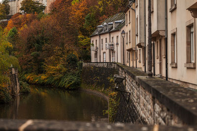 Canal amidst buildings in city during autumn