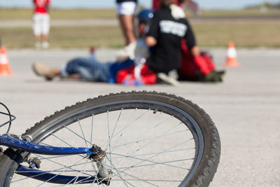 Close-up of bicycle against people on road