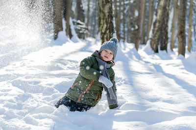 Boy playing on snow covered land