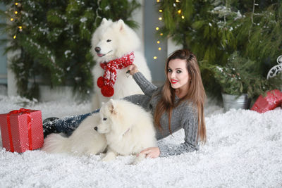 Young woman with dog in snow during winter