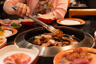 Midsection of woman serving food on dining table