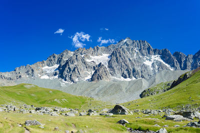 Scenic view of snowcapped mountains against blue sky