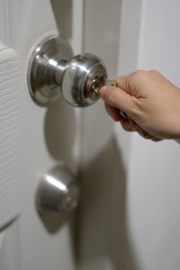 Close-up of human hand holding metal door