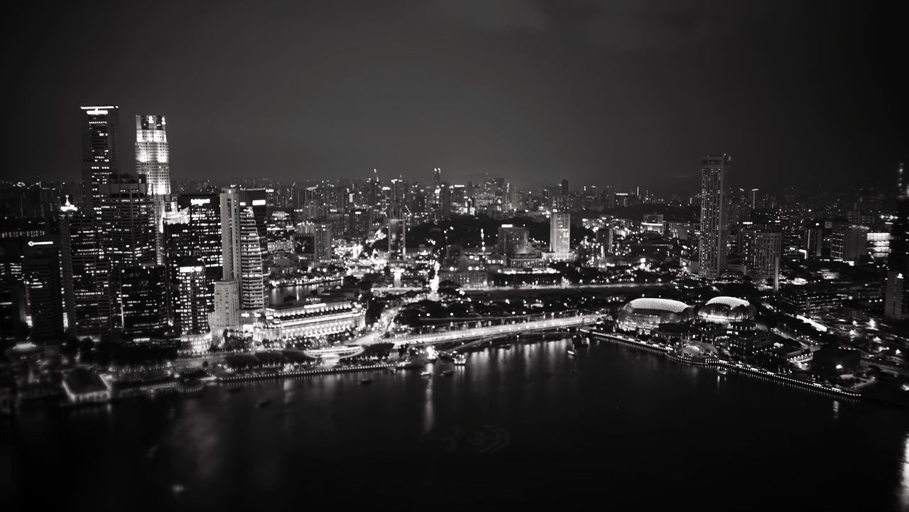 city, illuminated, cityscape, night, building exterior, architecture, built structure, water, river, reflection, crowded, skyscraper, urban skyline, waterfront, high angle view, residential district, sky, city life, modern, residential building