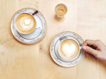 High angle view of woman and coffee cups on table