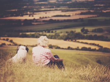 Woman with dog overlooking countryside landscape