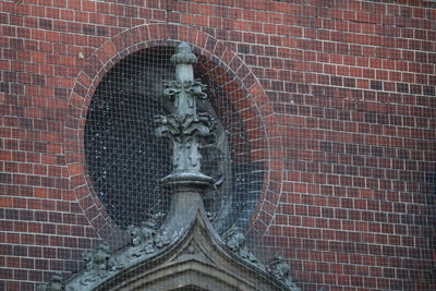 Low angle view of statue against brick wall