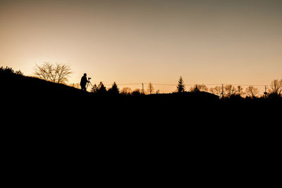 Silhouette man against clear sky at sunset