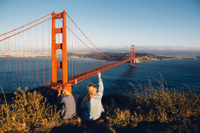 Rear view of woman looking at suspension bridge