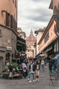 People walking on street amidst buildings in city