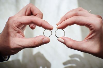 Cropped image of hands holding rings