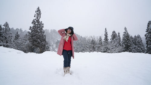Full length of woman standing on snow covered landscape
