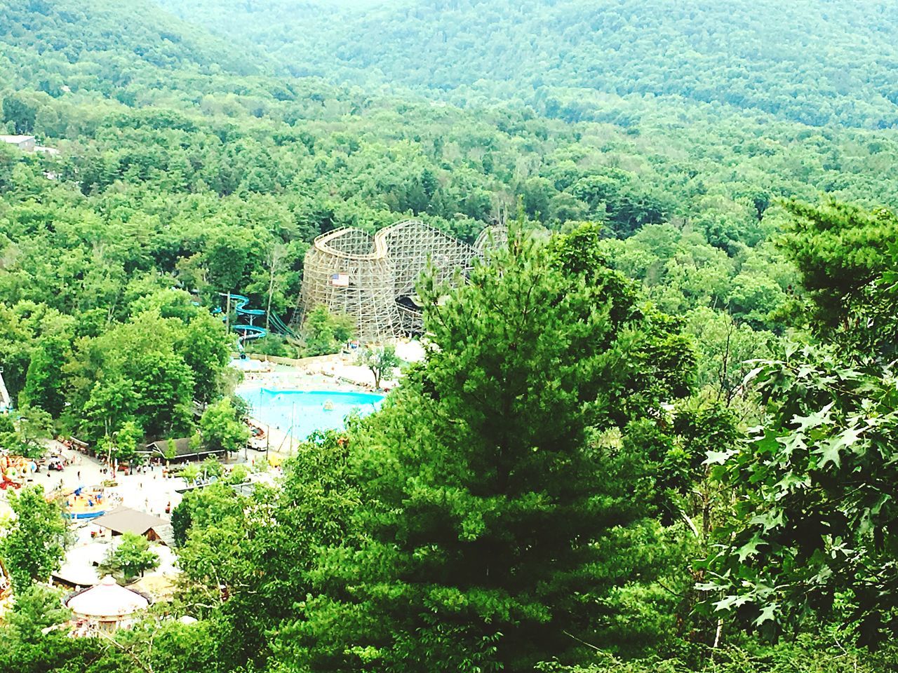 tree, green color, tranquil scene, scenics, lush foliage, architecture, tranquility, built structure, green, water, high angle view, landscape, idyllic, growth, nature, greenery, remote, mountain, beauty in nature, solitude, non-urban scene, plant, day, branch, calm, outdoors, blue, tourism, no people, majestic, sea