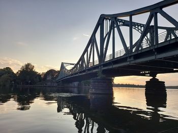 Low angle view of bridge over river during sunset