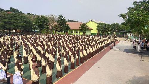 Group of people in row against trees