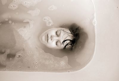 Close-up of smiling young woman in bathtub