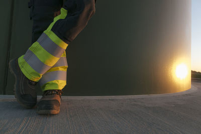 Legs of an engineer standing at a wind turbine tower