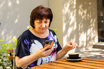 Young man using mobile phone on table