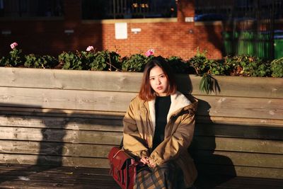 Portrait of beautiful young woman sitting outdoors