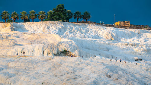 Scenic view of snow covered land against clear blue sky