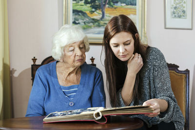 Grandmother and granddaughter looking at photo album