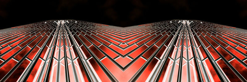 Low angle view of illuminated lighting equipment against black background