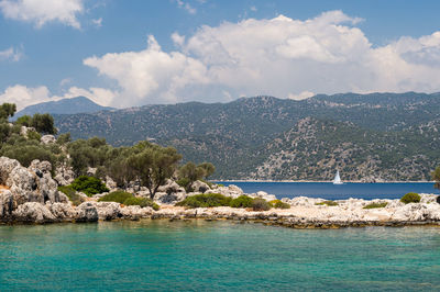 Scenic view of sea and mountains against sky