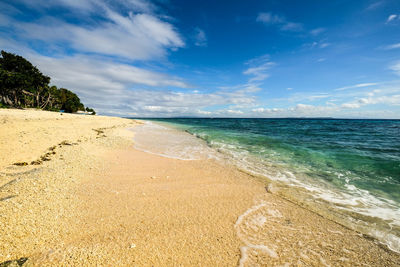 Scenic view of beach against blue sky