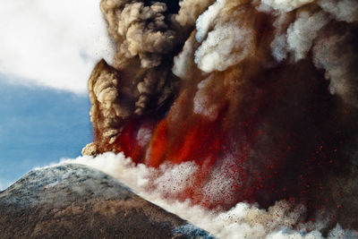 Smoke emitting from volcanic mountain against sky