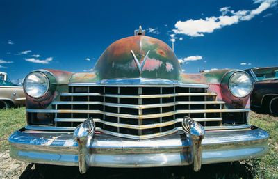 Close-up of vintage car against blue sky