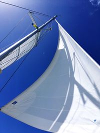 Low angle view of sailboat against clear blue sky