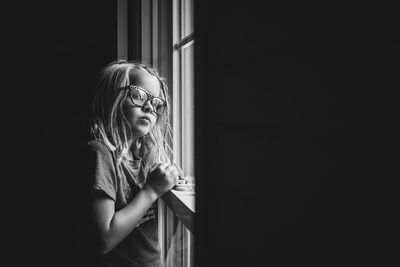 Close-up of girl looking out window